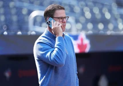 Toronto Blue Jays general manager Ross Atkins talks on the phone during batting practice before a game against the Baltimore Orioles at Rogers Centre