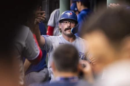 Toronto Blue Jays left fielder Davis Schneider (36) is greeted in the dugout after scoring off a single hit by shortstop Andrés Giménez (0), not pictured, in the third inning against the Boston Red Sox at Fenway Park.