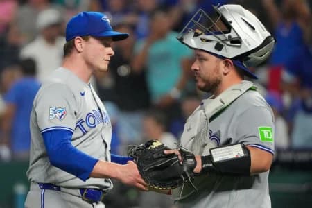 Toronto Blue Jays pitcher Louis Varland (77) celebrates with catcher Alejandro Kirk (30) after the win over the Kansas City Royals at Kauffman Stadium.