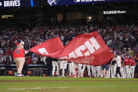 Atlanta Braves mascot Blooper waves a flag to celebrate after the Atlanta Braves defeated the Philadelphia Phillies in game three of the Wildcard round for the 2026 MLB Playoffs at Truist Field.