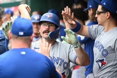 Toronto Blue Jays second baseman Davis Schneider (36) is congratulated by teammates after scoring a run against the Washington Nationals during the eighth inning at Nationals Park