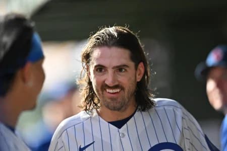 Chicago Cubs pitcher Kevin Gausman (12) smiles in the dugout against the Miami Marlins during the first inning at Wrigley Field.