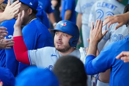Toronto Blue Jays catcher Alejandro Kirk (30) celebrates in the dugout after scoring against the Kansas City Royals during the first inning at Kauffman Stadium