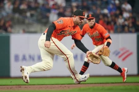 San Francisco Giants infielders Buddy Kennedy (41) and Christian Koss (50) move to field a ground ball hit by Colorado Rockies infielder Connor Norby (not pictured) during the second inning at Oracle Park.