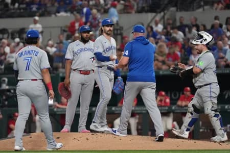 Toronto Blue Jays pitcher Dylan Cease (84) hands the baseball to manager John Schneider (14) as he is relieved during the third inning against the Texas Rangers at Globe Life Field.