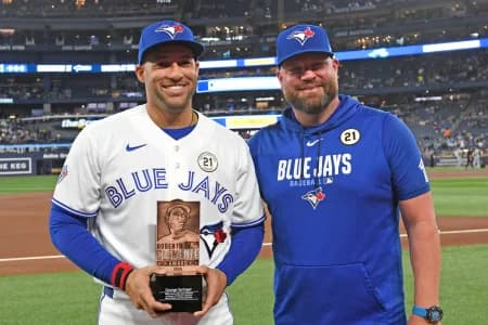 Toronto Blue Jays designated hitter George Springer (4) receives the team Roberto Clemente award from manager John Schneider (14) before play against the Detroit Tigers at Rogers Centre.